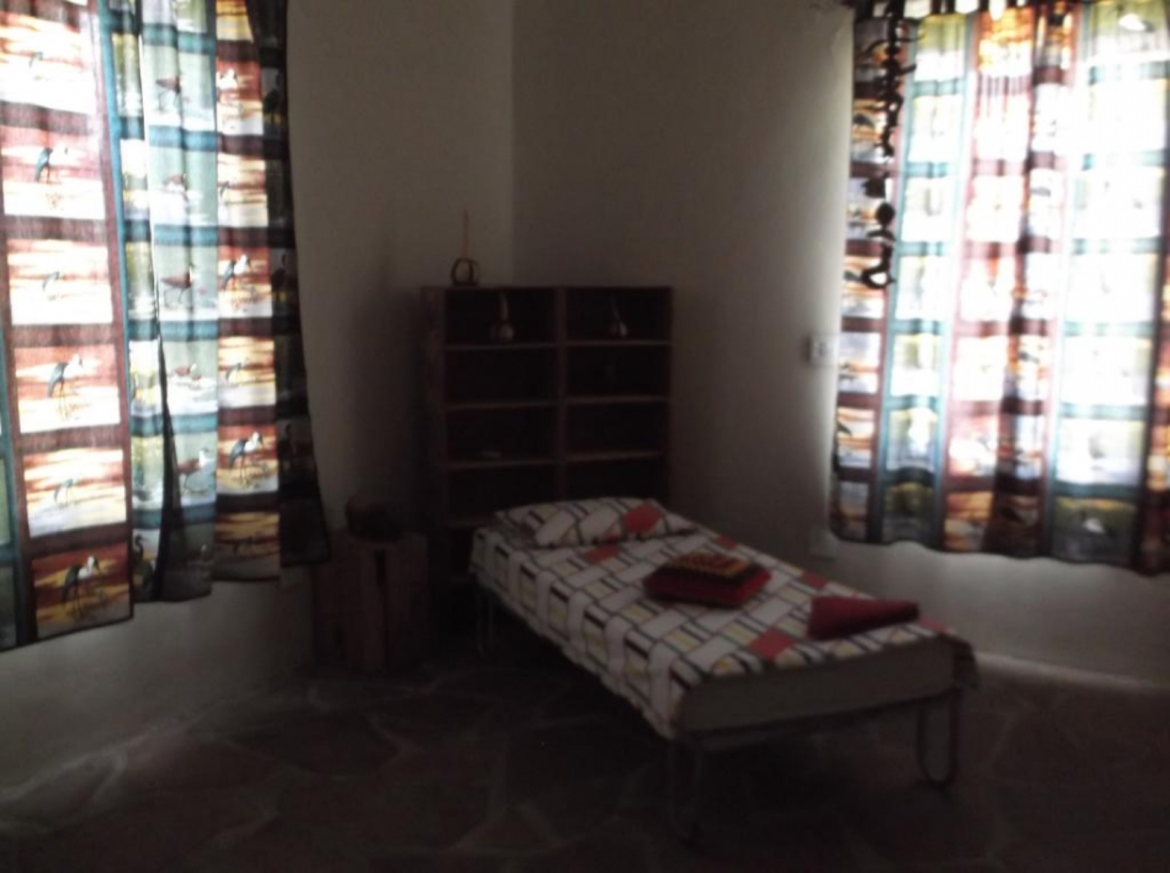 Bedroom with a single bed and patterned curtains