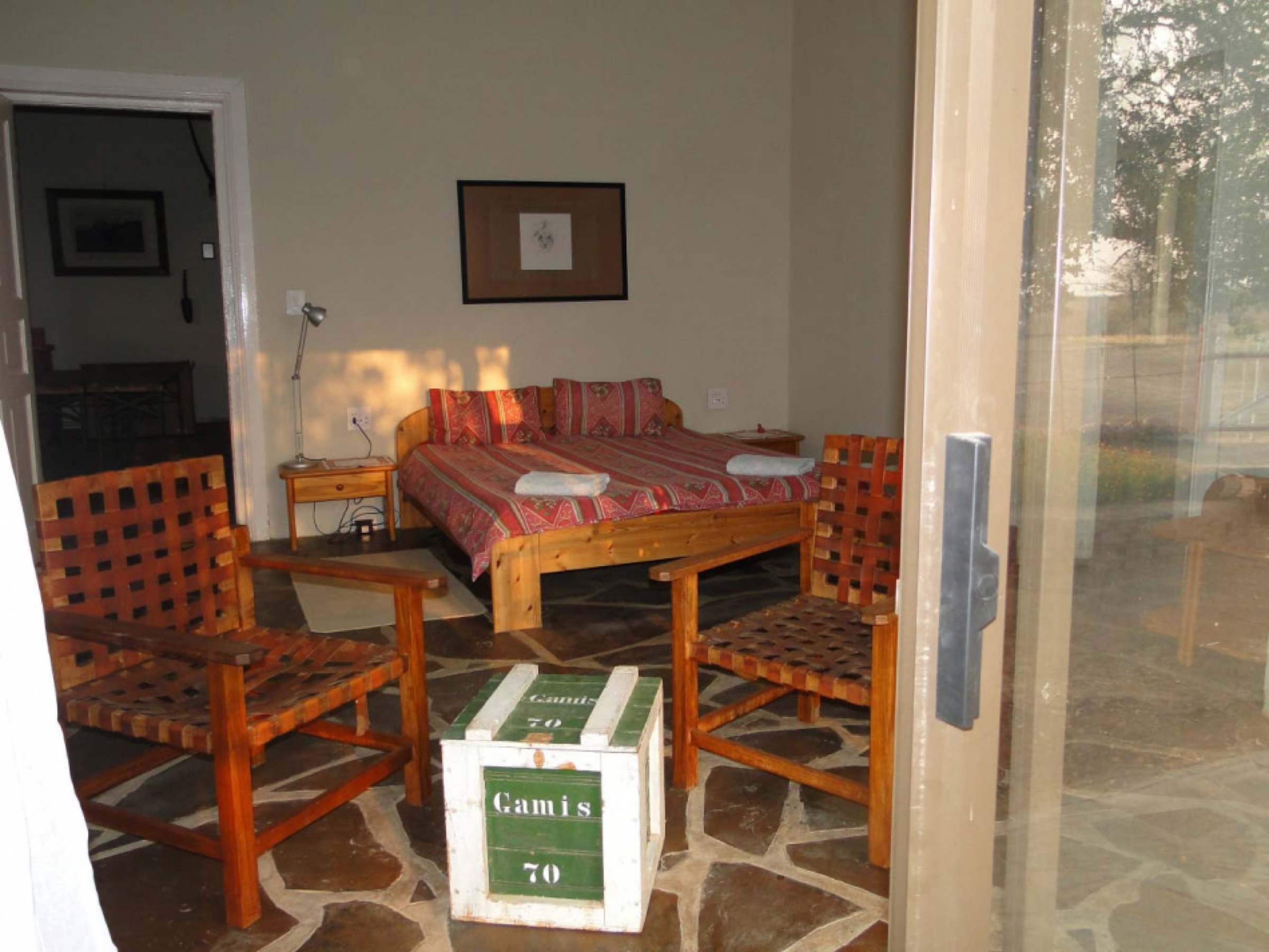 Sunroom with wooden chairs and a bed